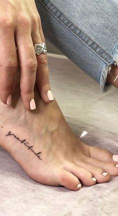 a woman is getting her foot tattooed with the words love and faith written on it