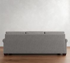 a gray couch sitting on top of a wooden floor