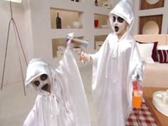 two children dressed up in halloween costumes, one holding a toothbrush and the other wearing a ghost costume