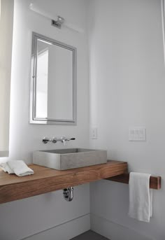 a bathroom with a sink, mirror and towel hanging on the wall above it's counter