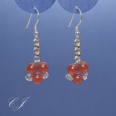 "I handmade these red carnelian earrings just for you. They are round gemstone beads, but they are arranged to resemble little red hearts. These cute little earrings will make a delightful addition to your Summer and Fall accessory collection. Ancient Byzantine and Assyrian cultures used Carnelian to foster courage, and so can you. Silver and gold filled jump rings provide a subtle contrast.  Please note: Gemstone beads are natural and therefore have slight variations in texture and color. The b Red Carnelian Round Bead Jewelry, Round Beaded Earrings With Natural Stones As Gift, Round Natural Stones Beaded Earrings As Gift, Red Round Agate Jewelry, Red Jewelry With Carnelian Gemstones, Red Jewelry With Gemstone Carnelian, Red Carnelian Gemstone Jewelry, Red Wire Wrapped Drop Earrings, Red Wire Wrapped Dangle Earrings