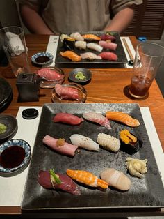 two trays of sushi on a wooden table