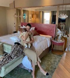 a woman sitting on top of a bed holding a stuffed animal