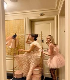 two women in pink dresses standing next to each other