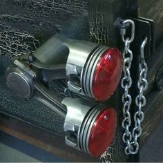 two red lights sitting on top of a metal chain