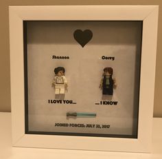 two lego minifigures in a shadow box with the words i love you