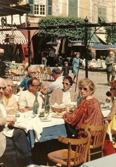 an old photo of people sitting around a table