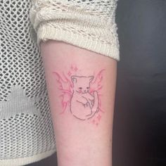 a woman's arm with a small tattoo of a bear holding a heart on it