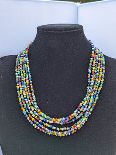 multicolored beaded necklace on display in front of a black mannequin