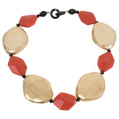 This refined Angela Caputi choker necklace, made in Italy, features gilded metallic coating resin elements contrasted with burnt orange flat beads. Each organic pebble bead is carved, dimensional, and geometric. Her color matching is always extremely classy, perfect for casual and fancy occasions. As you know, Caputi jewelry is not signed. This pre-owned necklace has no original label, but this piece has the brand's signature two-ring closing clasp. Angela Caputi has produced resin and Lucite je Resin Choker, Orange Flats, Gold And Orange, Choker Necklace Gold, Flat Beads, Lucite Jewelry, White Gold Necklace, Egyptian Revival, Gold Choker Necklace