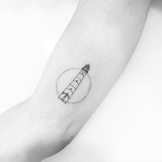 a black and white photo of a person's arm with a pencil tattoo on it