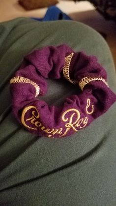 a purple scrunch with gold lettering on it