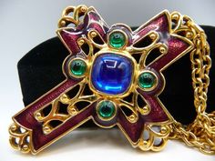 This is a beautiful 1992 AVON enameled cross on a gold tone chain necklace. It has a large glowing central cobalt faux sapphire cabochon and four emerald green cabs surrounding the central one. The cross is pierced and designed with shiny gold tone stylized flourishes from the Renaissance period. It is enameled in a deep burnt burgundy. No damages. Excellent vintage.      Hallmarks: © AVON on cross verso; AVON on chain closure. Size: Cross pendant: 2 7/16" L x 1 7/8" W on a 24" shiny cable chain. Lobster claw closure works fine.   Weight: 1.1 ounce Delivery confirmation and insurance included in postage. The Shop: https://www.etsy.com/shop/cherrylippedroses CLR -007 Avon Rings, Hey Diddle Diddle, Enamel Cross, Sapphire Cabochon, Avon Vintage, Avon Jewelry, Star Bracelet, Vintage Avon, Vintage Costume Jewelry