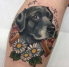 a black dog with flowers and stars around it's neck is on the arm