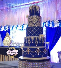 a three tiered blue wedding cake sitting on top of a table