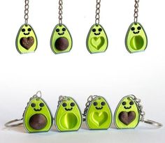 four pieces of green plastic with faces and hearts on them, hanging from metal chains