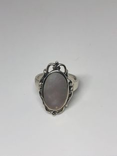 Lovely polished sterling silver has the look of Deco with a huge white Mother Of Pearl set in very detailed vintage filigree Size 7.75 We can size these with an additional $10-$20 fee for the jeweler All rings are shipped in a nice gift box. Check out our over a THOUSAND great reviews Engraving is $4 per letter and is not always perfect depending on the piece. It can take a few days if the jeweler is busy. This is payable to Paypal Judithsltd@gmail.com Pearl Filigree Ring, Elegant White Oval Mother Of Pearl Jewelry, Oval Mother Of Pearl Jewelry With Polished Finish, White Mother Of Pearl Round Pearl Ring, Luxury White Mother Of Pearl Ring, Pearl Set, Earrings Photo, Antique White, Antique Rings