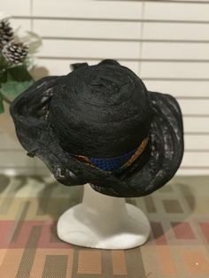 For those fun days out add a Zulu lace hat to your wardrobe. This lace crown has six different looks. The hat was inspired by my friendship with the Zulu women from Johasurburgh, from South Africa. Turn the hat to fit your mood. Every turn is a different expression. The kente cloth band is removable. This is a black lace hat with kente cloth. There is lace strings inside to give you the proper fit. This hat is pack friendly. This is a nice and simple statement that will turn heads. Great for fes Black Curved Brim Hats For Races, Black Brimmed Hat For Races, Black Brimmed Hats For Church, Black Brimmed Church Hat, Black Wide Brim Boater Hat For Church, Black Cloche Hat For Kentucky Derby And Beach, Black Wide Brim Hat For Kentucky Derby, Black Brimmed Boater Hat For Church, Black Hat For Festivals