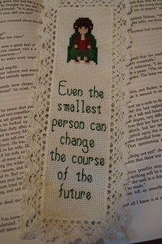 a cross stitch bookmark with the words, even the smallest person can change the course of the future