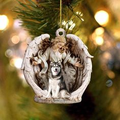 an angel ornament hanging from a christmas tree with a small dog in it