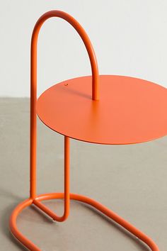 an orange table sitting on top of a cement floor