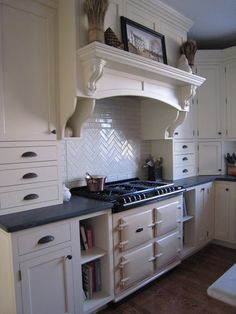 a kitchen with white cabinets and black counter tops