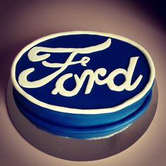 a blue and white ford logo cake sitting on top of a table