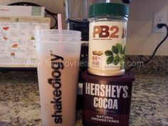 there is a smoothie next to a shaker on the counter with it's ingredients