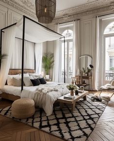 a bedroom with a canopy bed and white curtains on the window sill above it