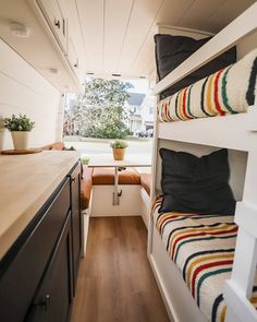 the interior of a small camper with bunk beds and kitchenette in it's center