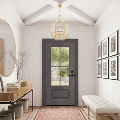 an entryway with a bench, mirror and pictures on the wall next to it