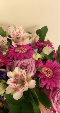 a vase filled with lots of purple and white flowers