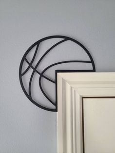 two metal circles are hanging on the wall next to a white door and framed photograph