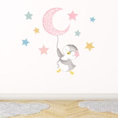 a wall decal with a penguin flying in the sky holding a crescent and stars