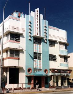 a tall building with many windows and balconies on the top floor, along side a street