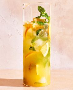 a tall glass filled with lemonade and mint