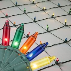 colorful lights are placed on top of a mesh net with small pins attached to it