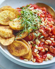 a white bowl filled with lots of food on top of a table