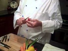 a man in a chef's outfit cutting up vegetables