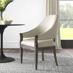 a dining room with a table and chairs next to a vase filled with yellow flowers