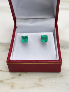 Featured here is a beautiful set of emerald cut Colombian emerald studs in fine 14K yellow gold. Displayed are vibrant-green emeralds with very good transparency, accented by a simple double-prong yellow gold mount, allowing for the emerald to be shown in full view. The earth-mined, green Colombian emeralds have a desirable lush green color with excellent qualities. These earrings are ideal for everyday use and are the perfect accessory to any outfit. Approx Total Carat Weight: 2.50tcw Setting S Emerald-cut Emerald Jewelry For May Birthstone, Emerald Rectangular Earrings For May Birthstone, Rectangular Emerald Earrings Fine Jewelry, Emerald Earrings For May Birthstone, Round Cut, Multi-stone Emerald Earrings For Gift, Emerald Earrings Studs, Colombian Emeralds, Birthstone Gifts, Emerald Earrings