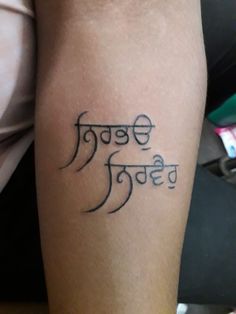 a person with a tattoo on their arm that reads, in the language of india