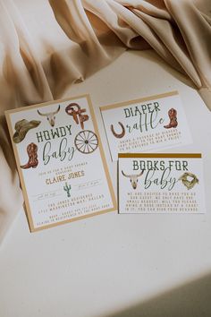 two wedding stationery cards on top of a table