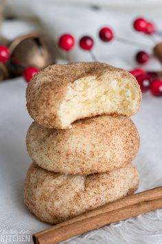 cinnamon sugar donuts stacked on top of each other next to cinnamon sticks and cranberries