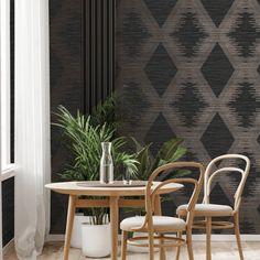 two chairs and a table in front of a patterned wall