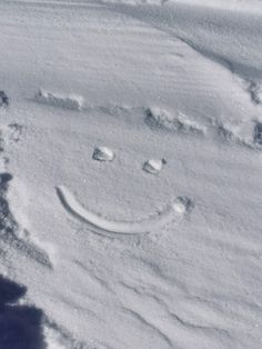 a smiley face drawn in the snow