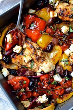 a pan filled with chicken and vegetables on top of a table