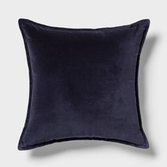 a dark blue velvet pillow on a white background