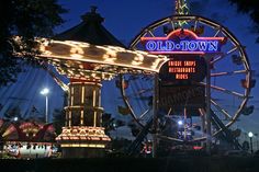 an amusement park at night with lights on