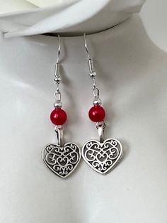 Red pearl and heart drop earrings. Add a touch of elegance to your wardrobe with these timeless earrings. Handmade with love to elevate any look or outfit.  Sterling silver ear hooks with a red faux Pearl and heart drop design.    Free shipping to UK buyers. Dispatched within 1-3 days but I aim for next day postage.  Presented on a gift card and wrapped beautifully to make these the prefect gift for loved ones.  If you aren't completely in LOVE with your purchase, please let me know and you'll receive a stress free refund. Customer satisfaction Is my main priority.  These are perfect for any occasion. Thank you for viewing and supporting a small business.  Please ask any questions, I am always available to help.  If you have a spare moment please view my other pieces in my shop.  Kind rega Silver Pearl Earrings For Valentine's Day, Silver Heart Earrings With Pearl Drop, Silver Heart-shaped Pearl Earrings For Valentine's Day, Elegant Red Heart Charm Earrings, Elegant Red Earrings With Heart Charm, Valentine's Day Pearl Earrings For Party, Elegant Red Double Heart Earrings, Heart-shaped Pearl Earrings For Valentine's Day, Silver Heart-shaped Pearl Earrings For Gift